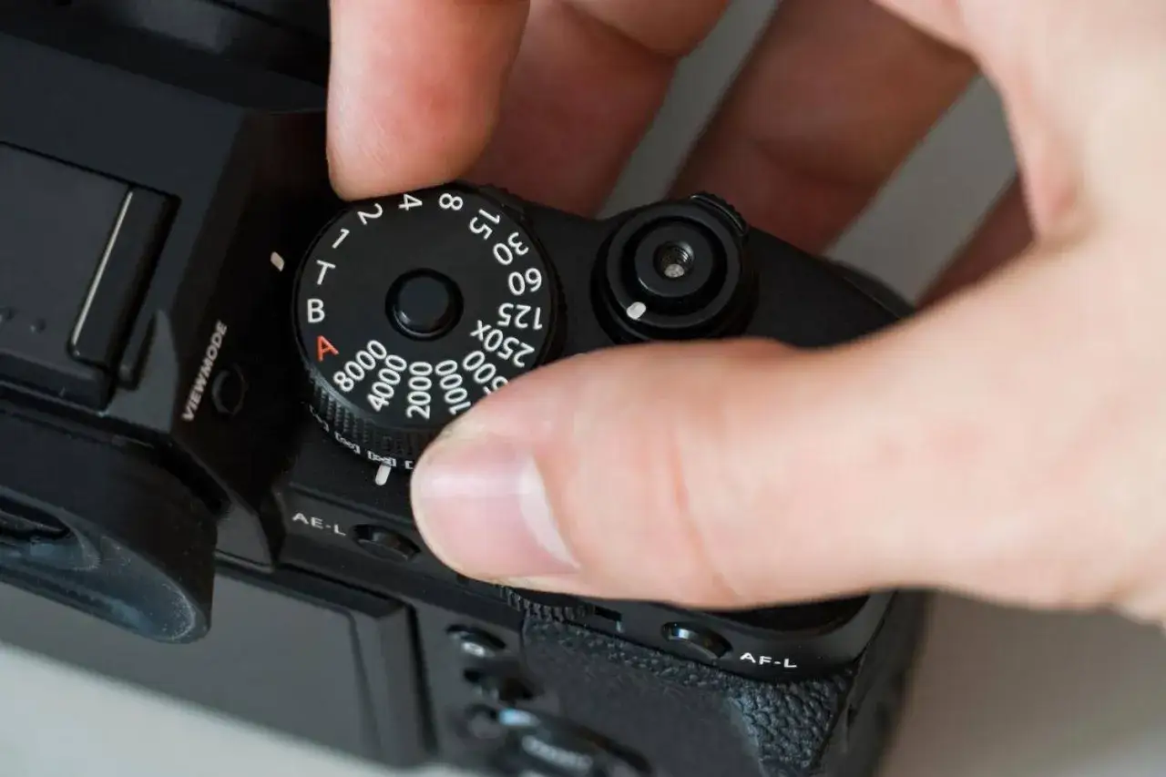 Ajustando el dial de la c&aacute;mara para cambiar el ISO, un valor clave para entender que es el ISO de una c&aacute;mara.